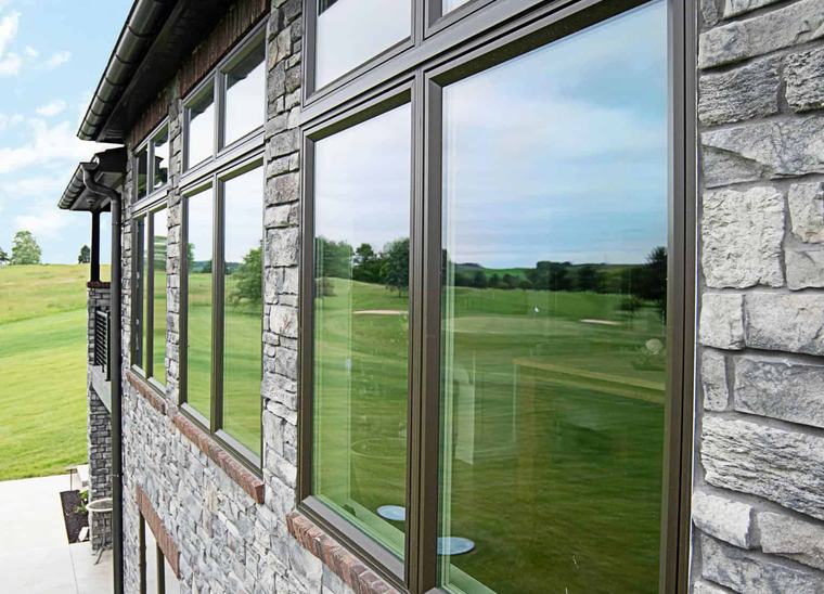 A row of ProVia casement windows on a stone-and-siding exterior