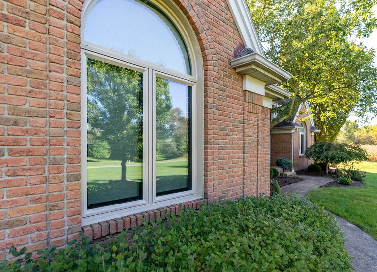 A custom arched-top ProVia window in a brick exterior wall